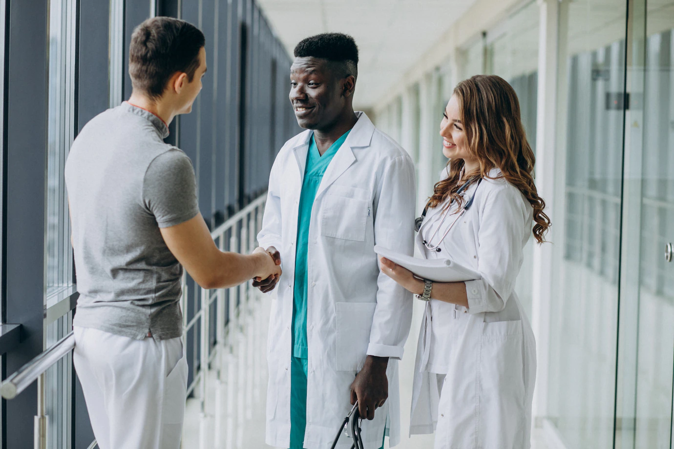 doctors-shaking-hands-with-patient-standing-corridor-hospital_1303-21238